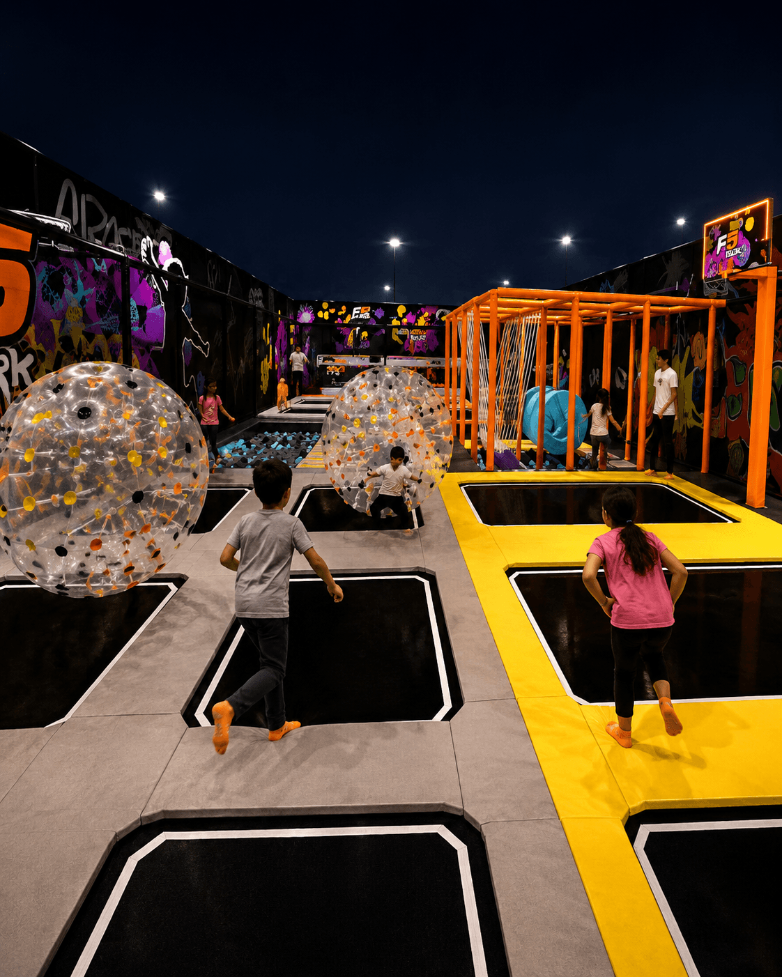 Chicos jugando entre camas elásticas y burbujas gigantes en F5 Air Park