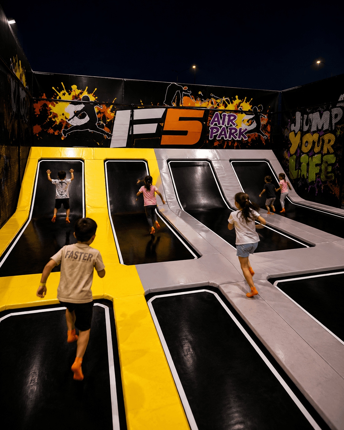 Chicos corriendo por las rampas y camas elásticas de F5 Air Park